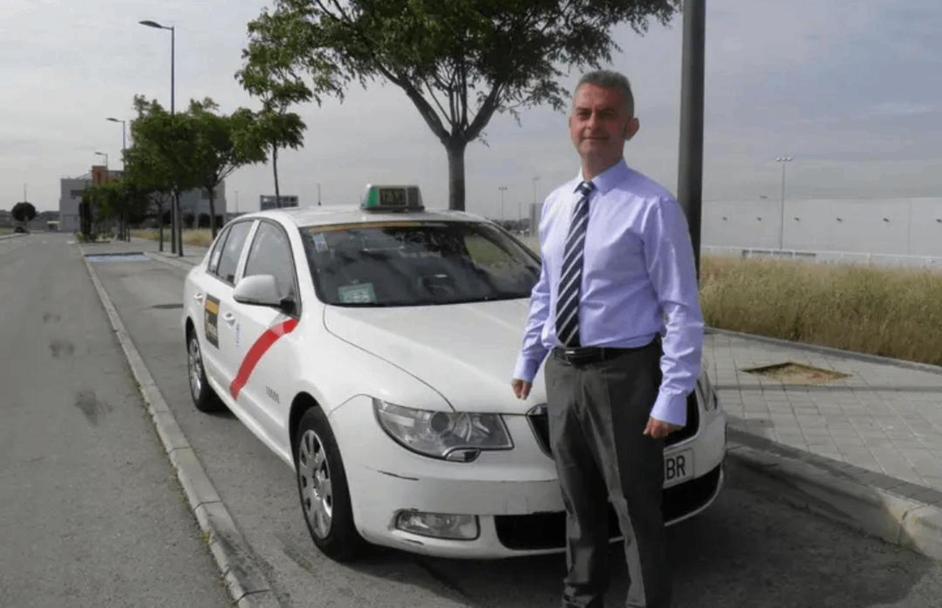 Conductor de camisa y corbata al lado de un taxi